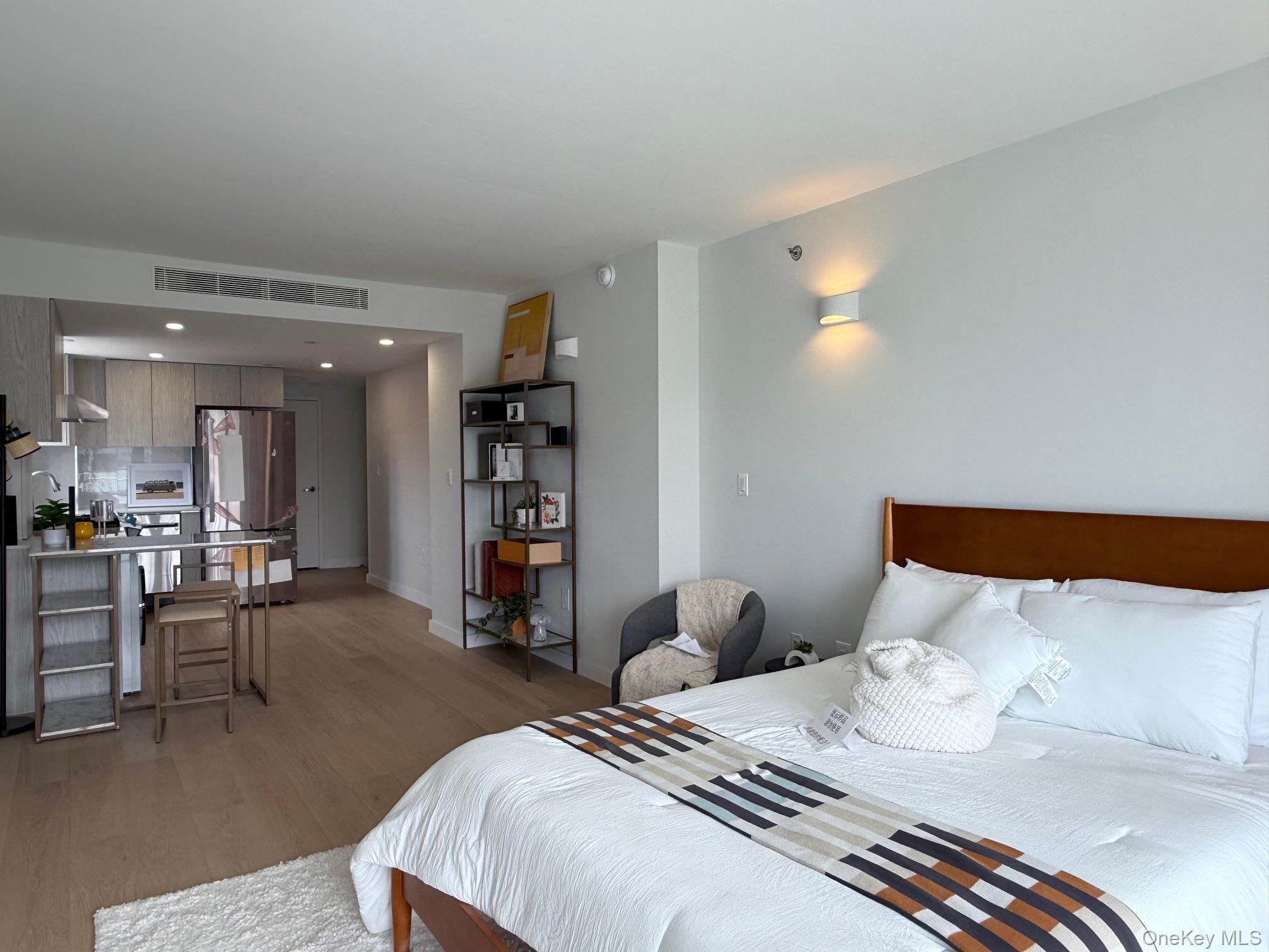 136-80 41st Avenue, Unit 6H Queens, NY 11355 - Photo 8 of 11 a bedroom with furniture and a wooden floor