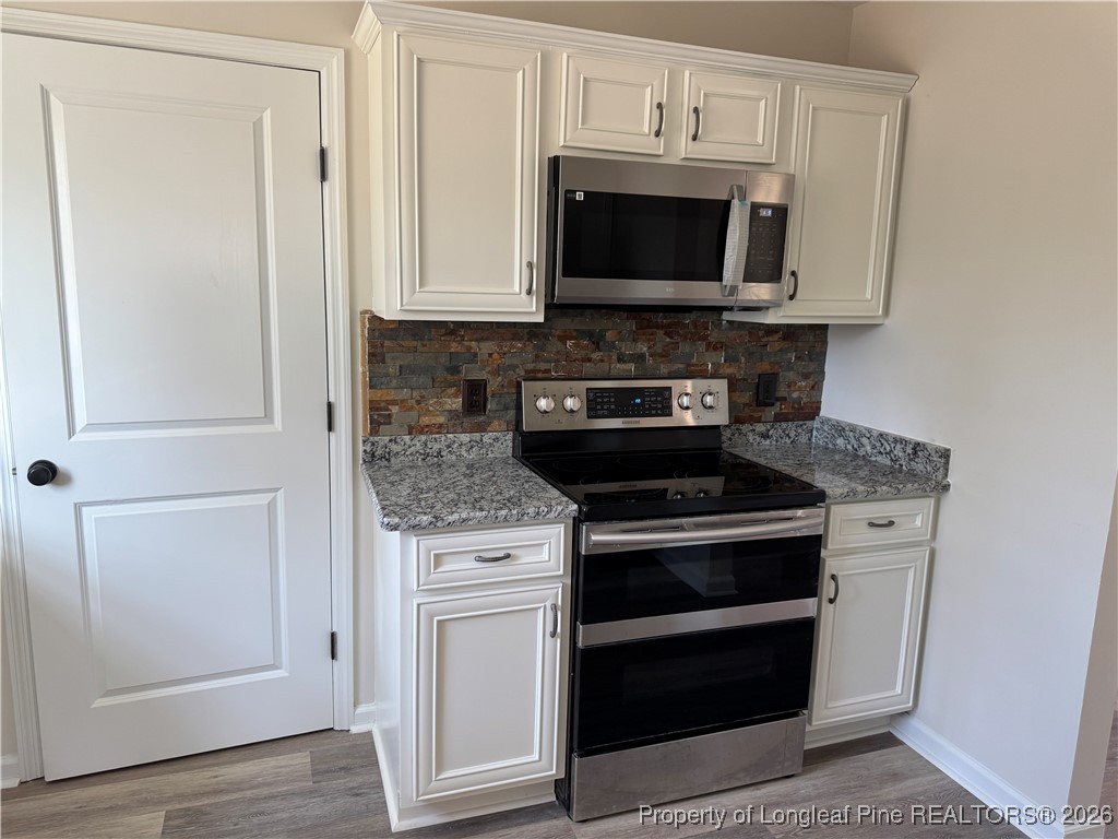 1950 Tingen Road Lillington, NC 27546 - Photo 17 of 50 a kitchen with stainless steel appliances a stove a microwave and a sink