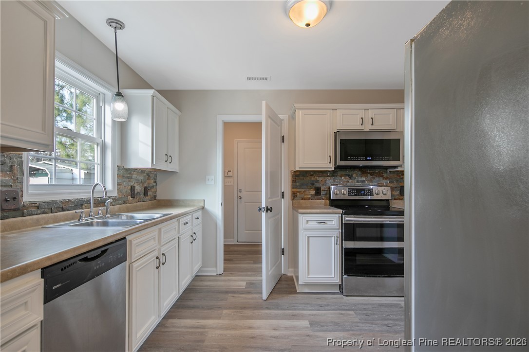 1950 Tingen Road Lillington, NC 27546 - Photo 19 of 50 a kitchen with stainless steel appliances a stove and a sink