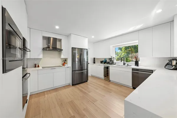 a kitchen with stainless steel appliances a refrigerator sink and microwave