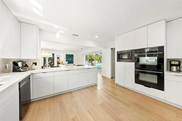 a kitchen with wooden floors and white appliances
