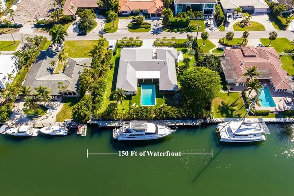 a view of a swimming pool with a yard and plants
