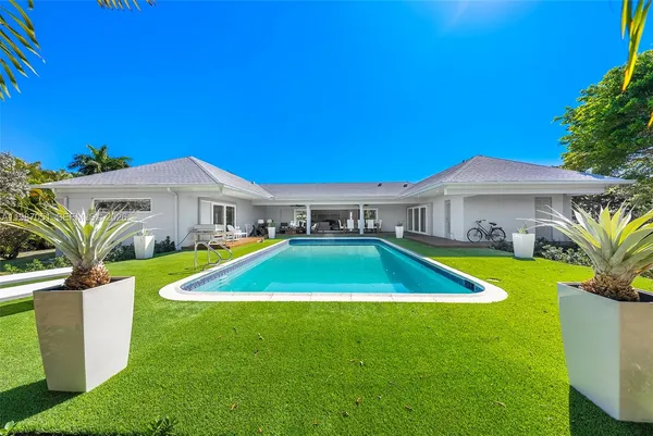 a view of a house with swimming pool and a yard