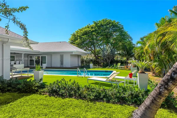 a house view with garden space and trees