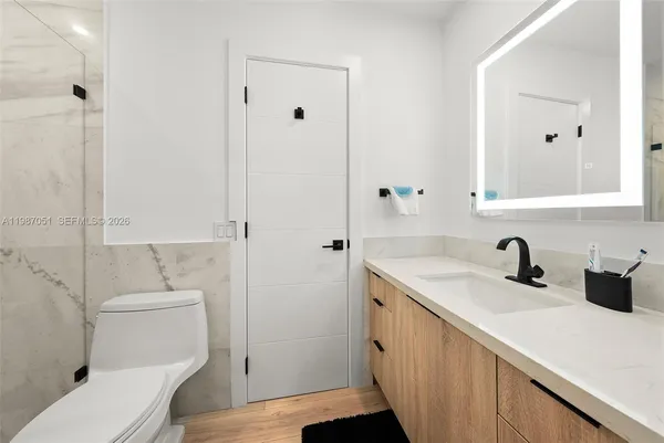 a white toilet sitting next to a bath tub and shower