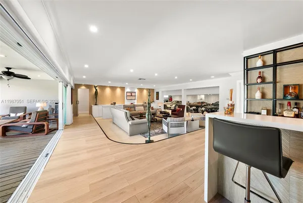 a dining hall with stainless steel appliances kitchen island granite countertop a refrigerator and cabinets