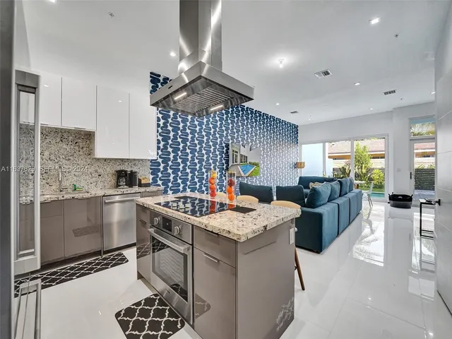 a kitchen with stainless steel appliances granite countertop a sink a stove and a refrigerator
