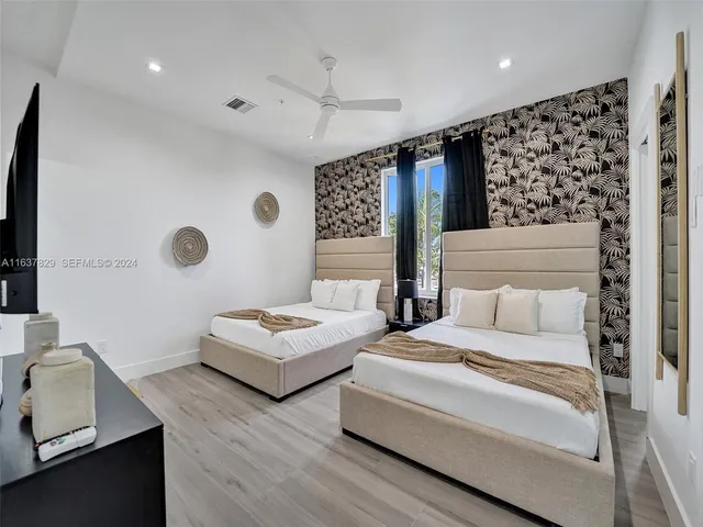 a spacious bedroom with two beds and a window