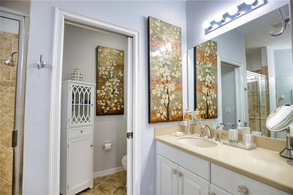 a en suite bathroom with a granite countertop sink mirror and a shower