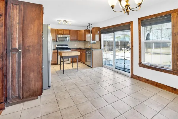 a open kitchen with stainless steel appliances granite countertop a refrigerator and a stove top oven