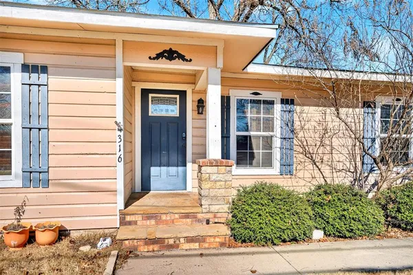 a front view of a house with a yard and seating space