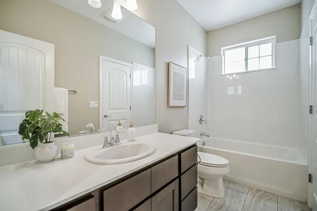 an aerial view of residential houses with outdoor space and trees