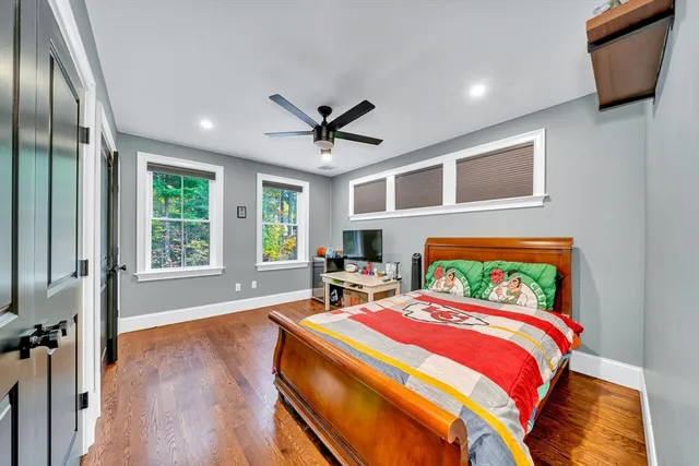 a bedroom with a bed and wooden floor