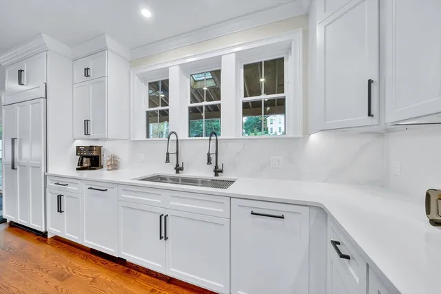 a kitchen with white cabinets and a window