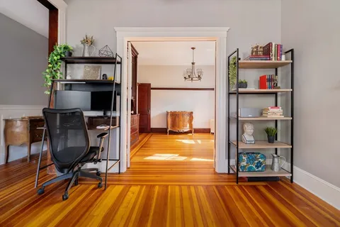 a view of a workspace with furniture and wooden floor