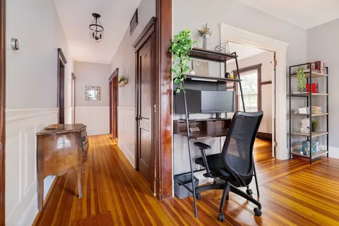 a view of a workspace with furniture and wooden floor
