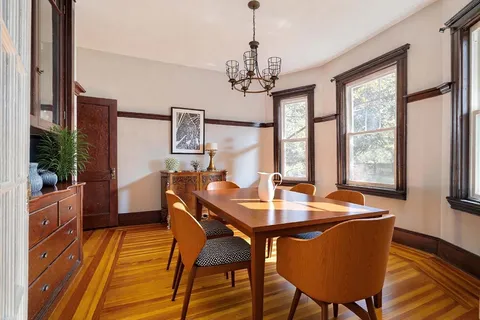 a dining room with furniture a chandelier and wooden floor