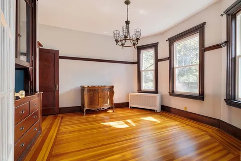 a bedroom with furniture a chandelier and wooden floor