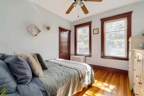 a bedroom with a bed and wooden floor