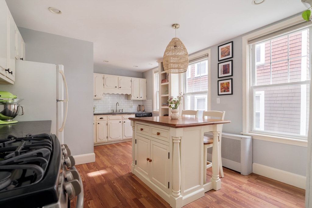250 Poplar Street, Unit 1 Boston, MA 02131 - Photo 5 of 34 a kitchen with granite countertop a sink stove and cabinets
