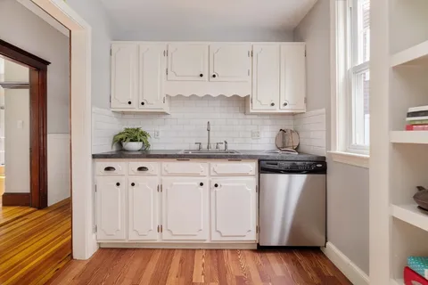 a kitchen with granite countertop white cabinets and white appliances