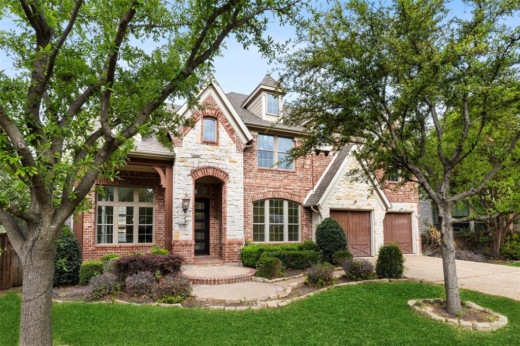 a front view of a house with a yard and green space