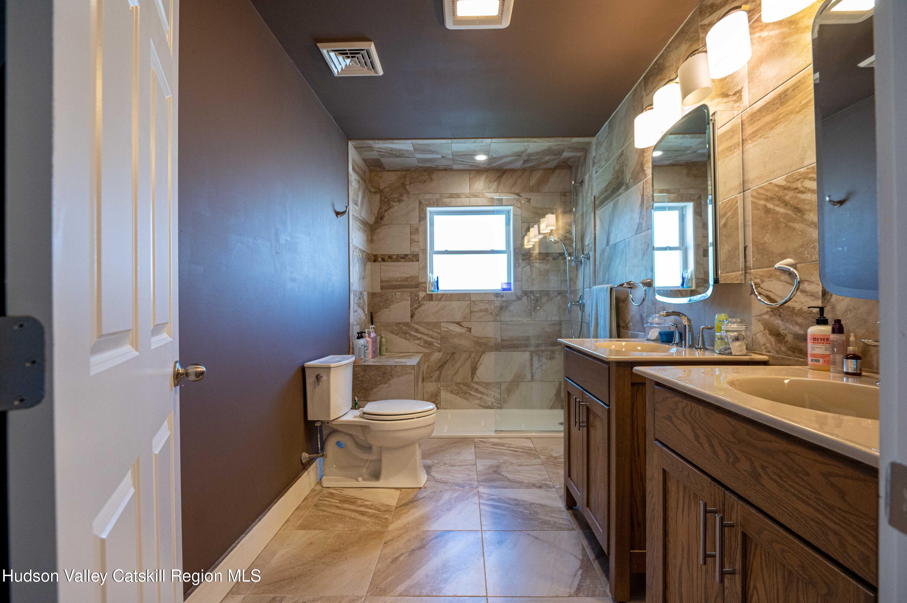 225 State Street, Unit RIGHT Hudson, NY 12534 - Photo 22 of 29 a bathroom with a sink a toilet a mirror and vanity