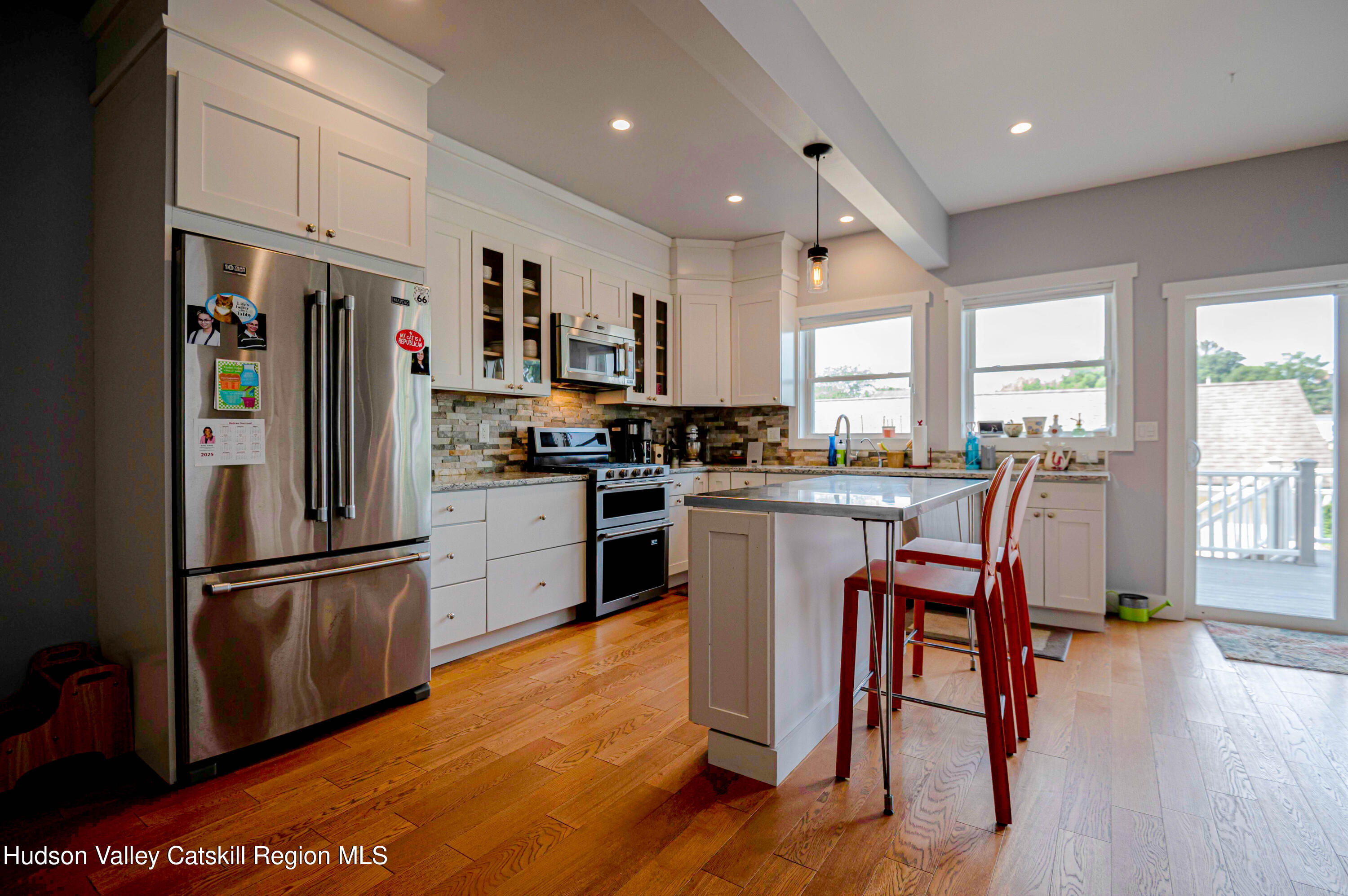 225 State Street, Unit RIGHT Hudson, NY 12534 - Photo 10 of 29 a kitchen with granite countertop stainless steel appliances a refrigerator a counter top space and a center island