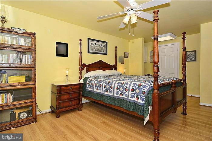 14424 Basingstoke Lane Silver Spring, MD 20905 - Photo 19 of 29 a bedroom with a bed dresser and a book shelf