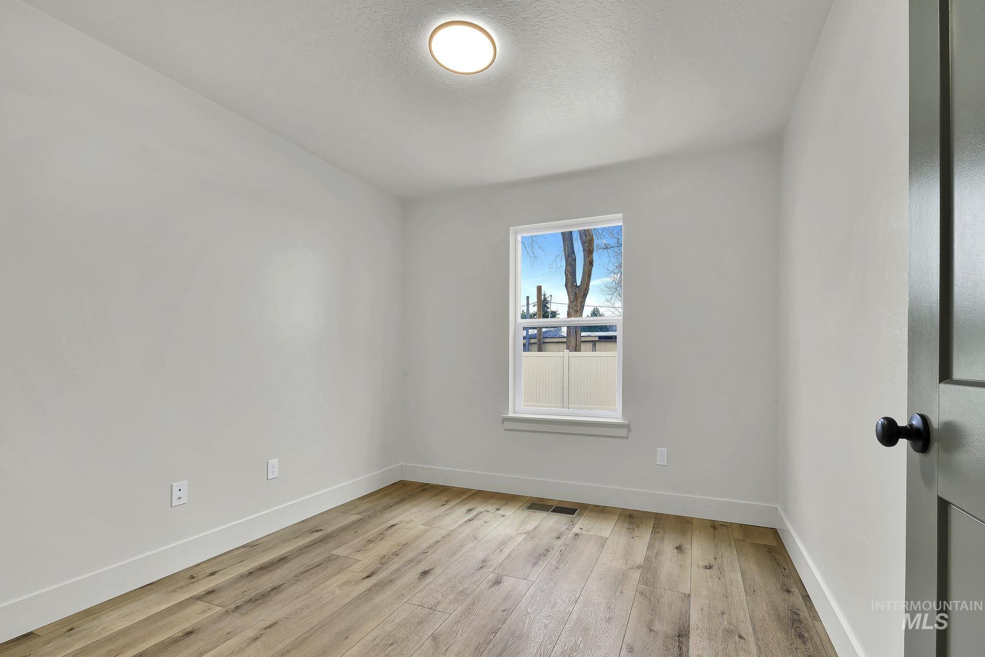 1130 Velvet Loop Wilder, ID 83676 - Photo 16 of 35 Room with wood-finish flooring, white walls, and a recessed window