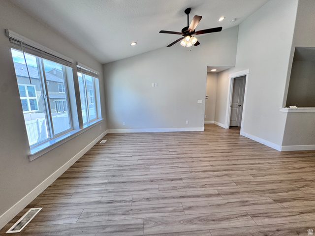 12339 Remy Road, Unit 422 Herriman, UT 84096 - Photo 19 of 36 Empty room featuring a ceiling fan, light wood-style floors, vaulted ceiling, and recessed lighting