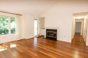 1 Upland Circle, Unit 1 Mashpee, MA 02649 - Photo 6 of 39 an empty room with wooden floor fireplace and windows