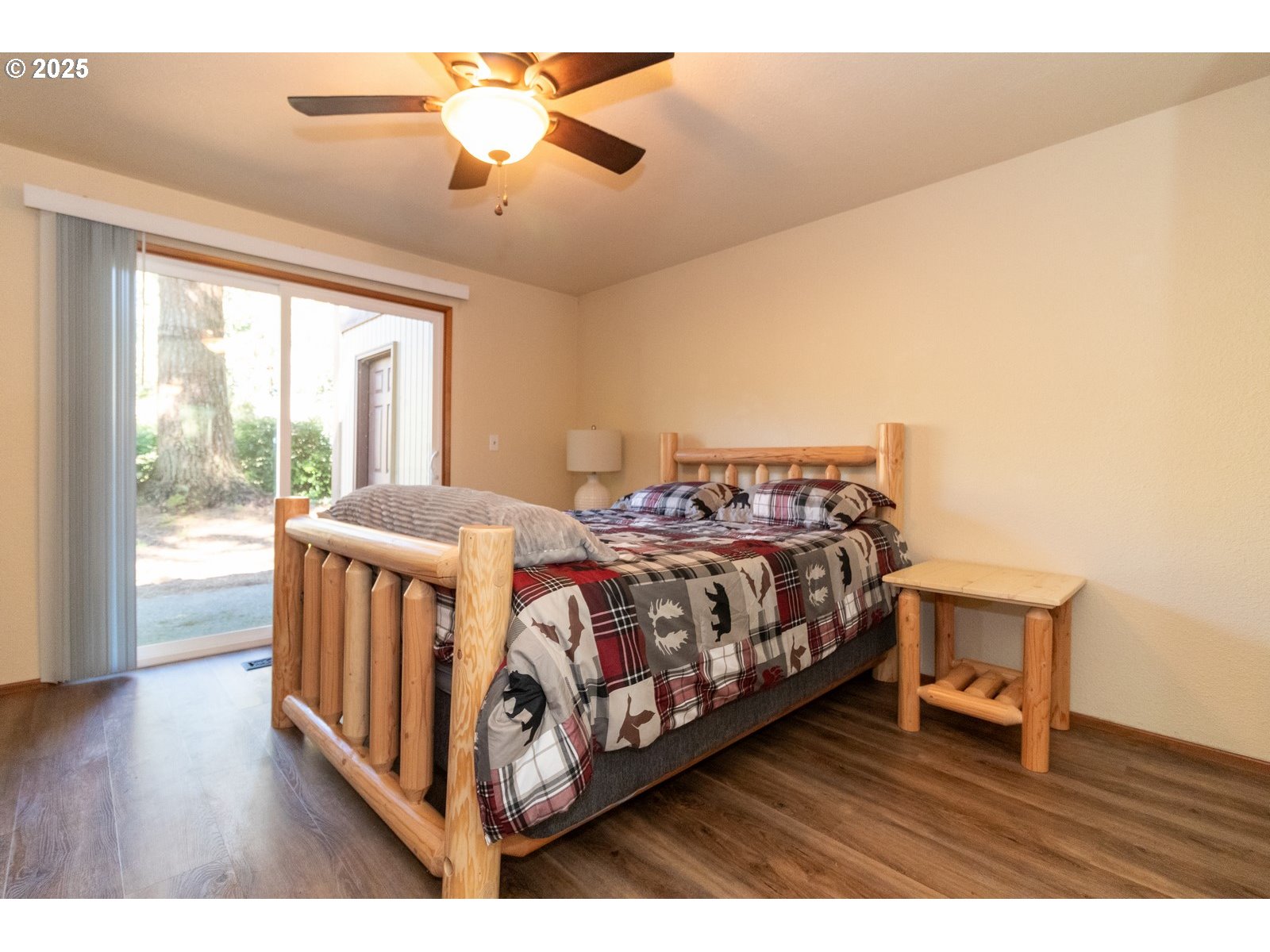 83694 Erhart Road Florence, OR 97439 - Photo 15 of 31 a bedroom with a bed next to a large window with wooden floor