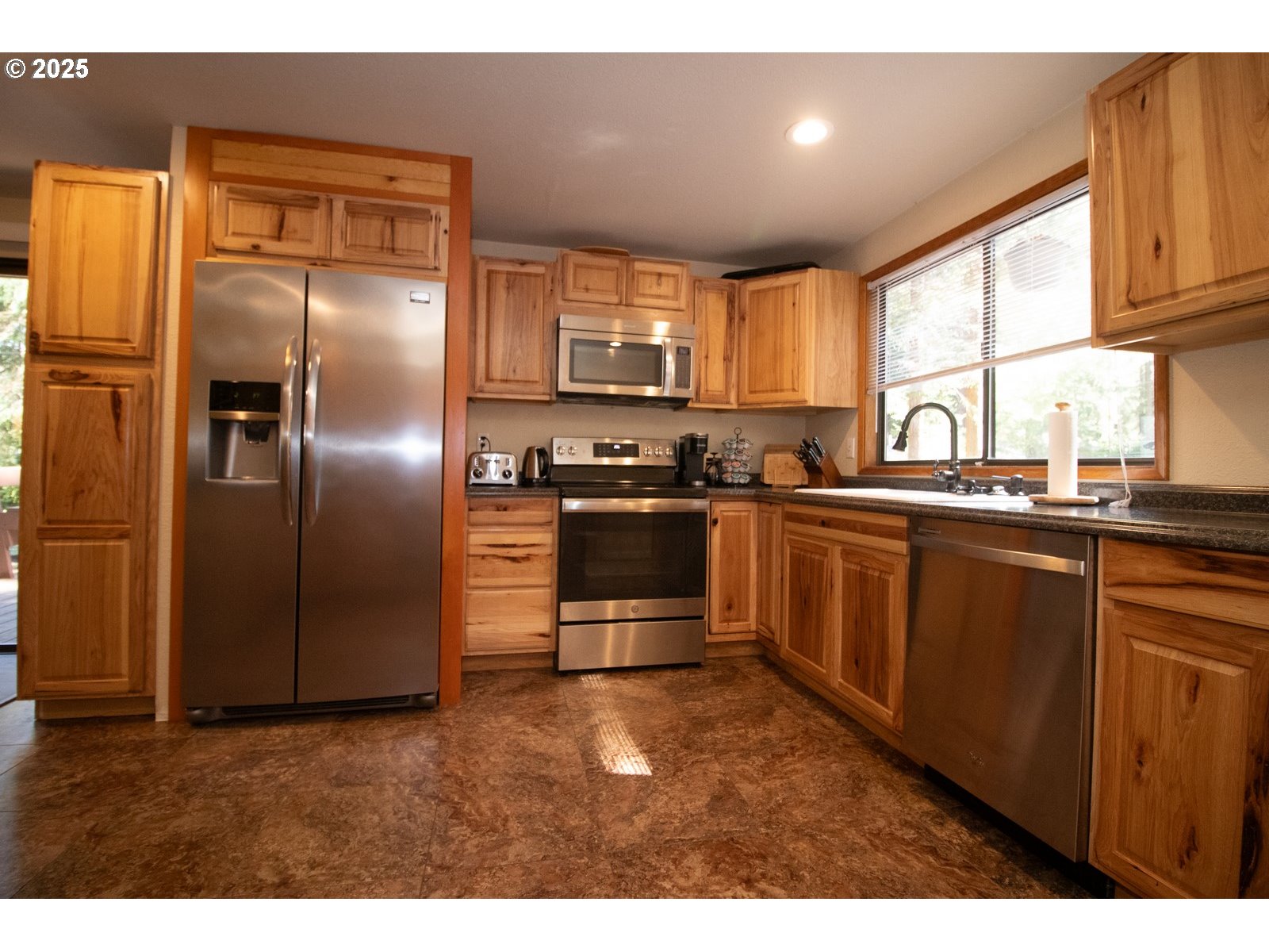 83694 Erhart Road Florence, OR 97439 - Photo 5 of 31 a kitchen with stainless steel appliances granite countertop a sink a stove a refrigerator with grey cabinets