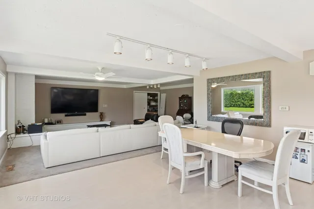 a living room with furniture a flat screen tv and a large window