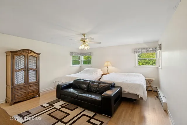 a bedroom with a bed wooden floor and window