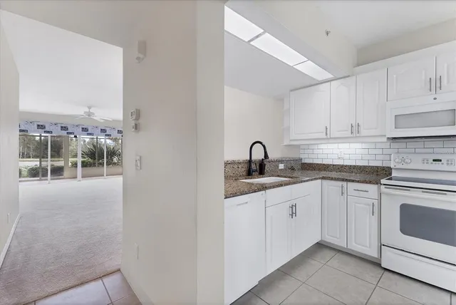 a view of a kitchen with white cabinets