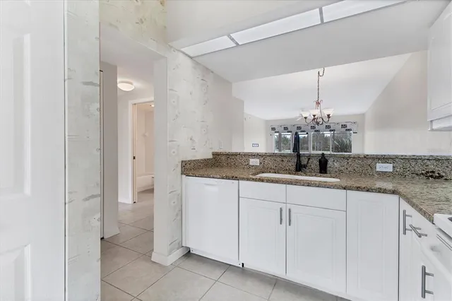 a view of a kitchen with a sink and white cabinets