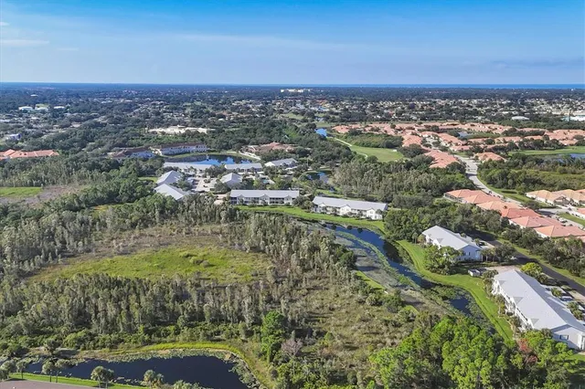 an aerial view of a house with a garden and lake view