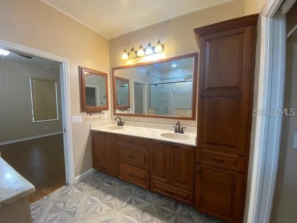 a bathroom with a double vanity sink and a mirror