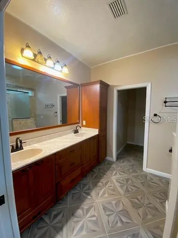 a bathroom with a double vanity sink and a mirror