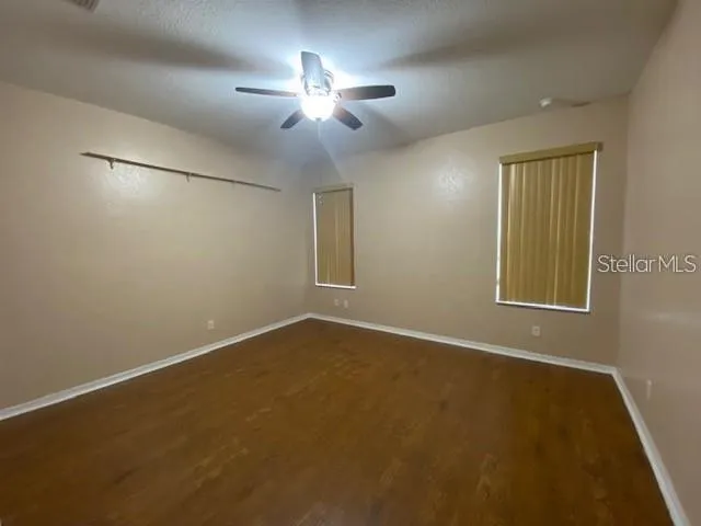an empty room with closet and windows