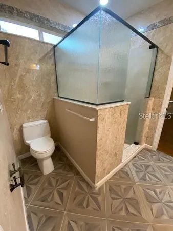 a bathroom with a toilet and a shower