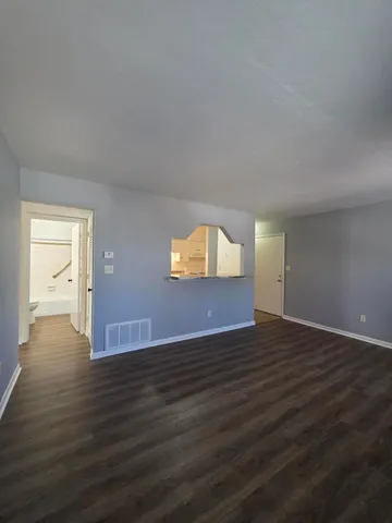 a view of an empty room and wooden floor and a window