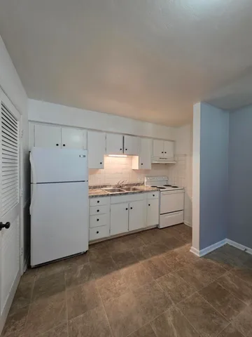 a utility room with cabinets washer and dryer
