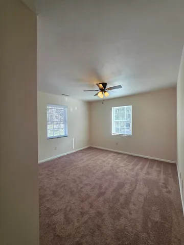 an empty room with a window and ceiling fan