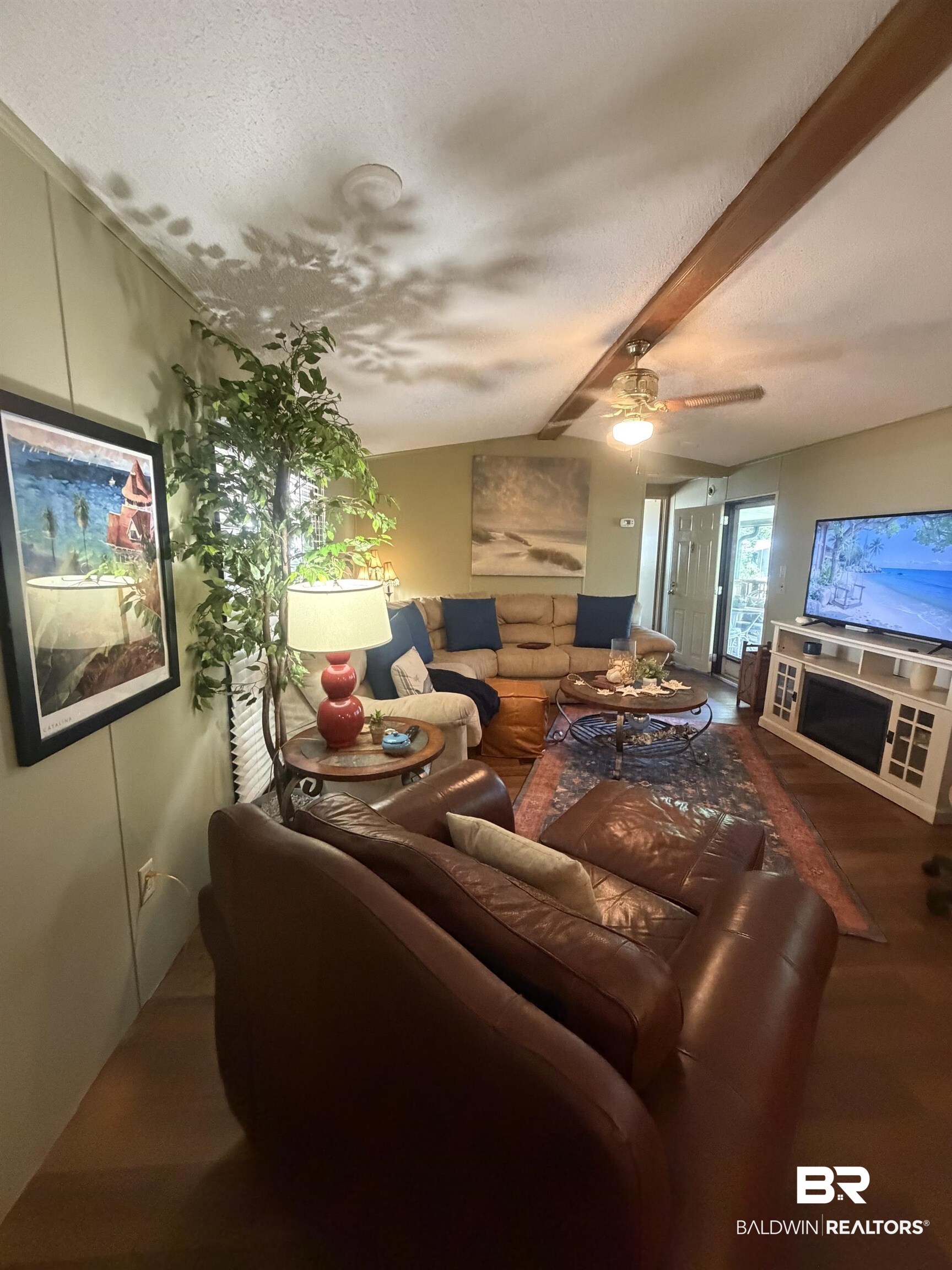 1620 Del Rey Drive Lillian, AL 36549 - Photo 8 of 45 Living area featuring wood-finish flooring, a ceiling fan with integrated lighting, and a prominent wood beam accent