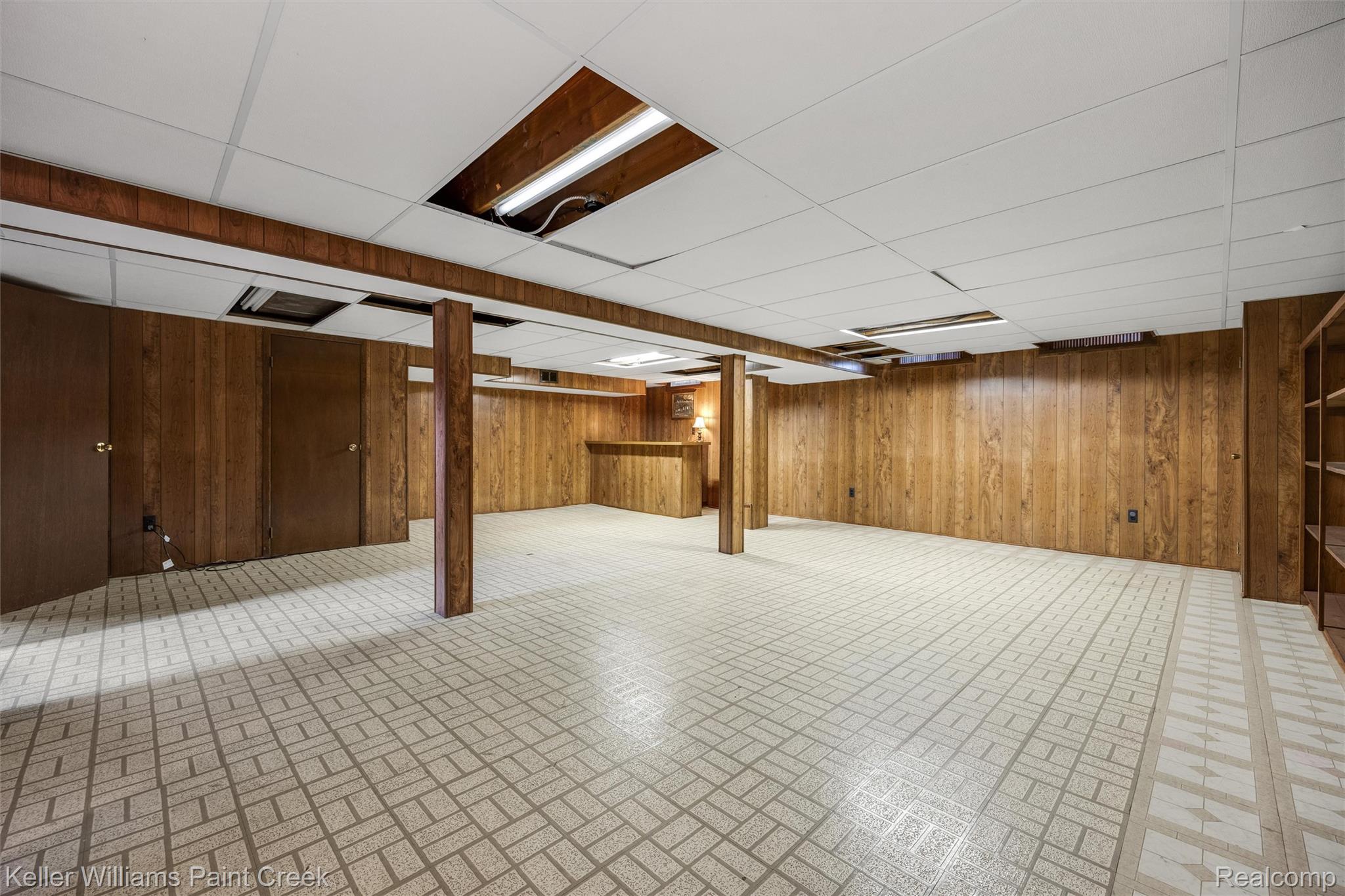 1766 Henry Ruff Road Garden City, MI 48135 - Photo 19 of 36 Expansive room featuring wood-finish wall paneling, ceiling with recessed lighting, patterned floor tile, and built-in shelving