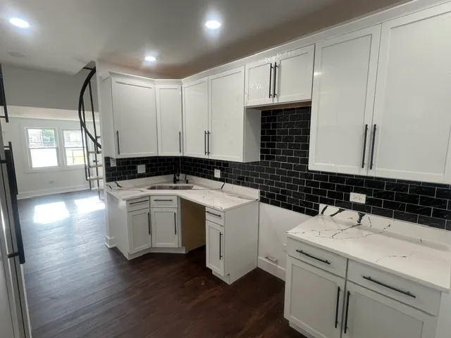 a kitchen with stainless steel appliances a sink a stove a refrigerator a sink a counter top space and cabinets