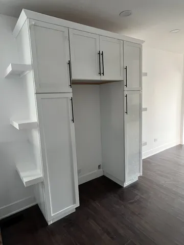 a view of an empty room with stairs and wooden floor